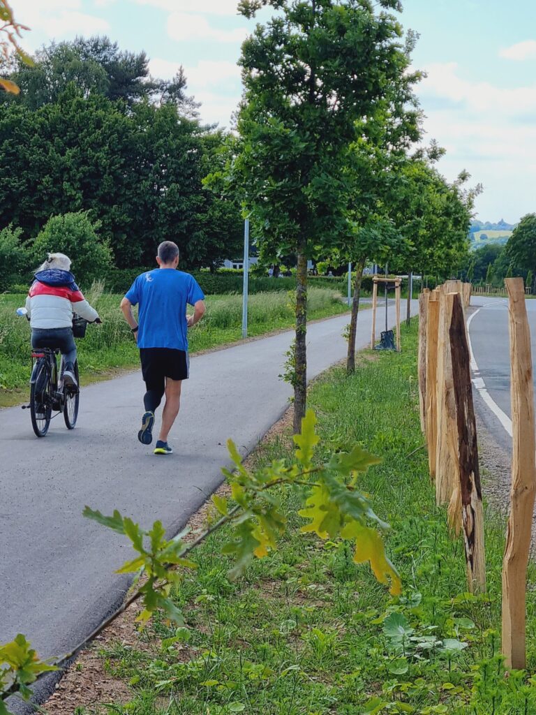 Radweg Kuhlenhagen. Ein Raffahrer und ein Läufer mit Beinprothese