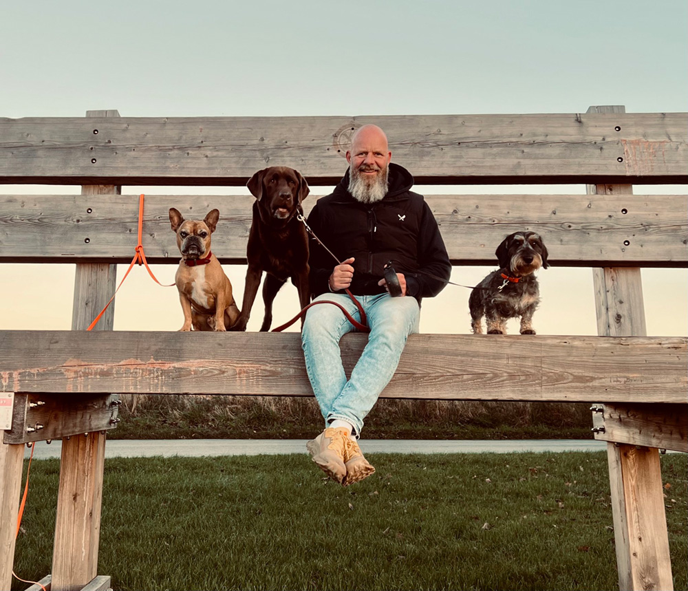 Jochen Berbsdorf mit drei Hunden sitzt auf der XXL-Bank in Schalksmühle